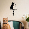 Black metal cat wall art in living room with orange cat