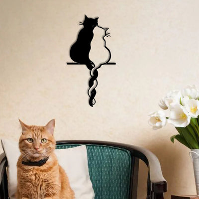 Black metal cat wall art in living room with orange cat