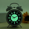 Luminous retro twin bell alarm clock on desk